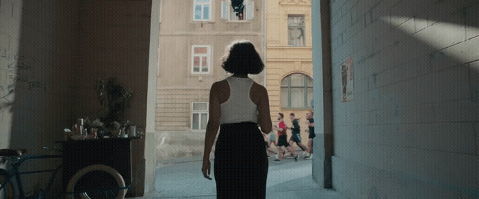 a woman walking down a narrow alley way