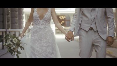 a bride and groom holding hands walking down a street