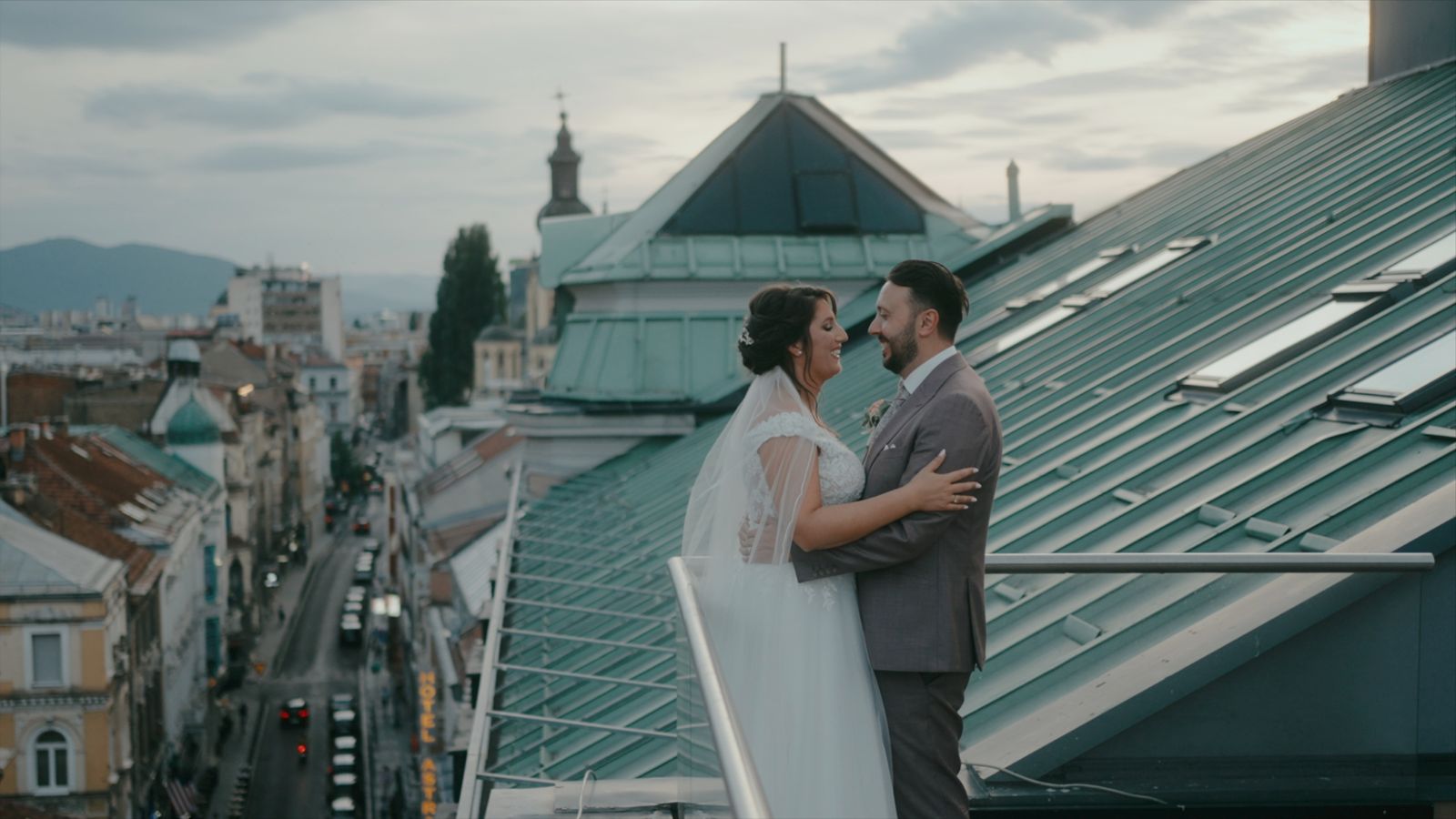 a bride and groom standing on the roof of a building