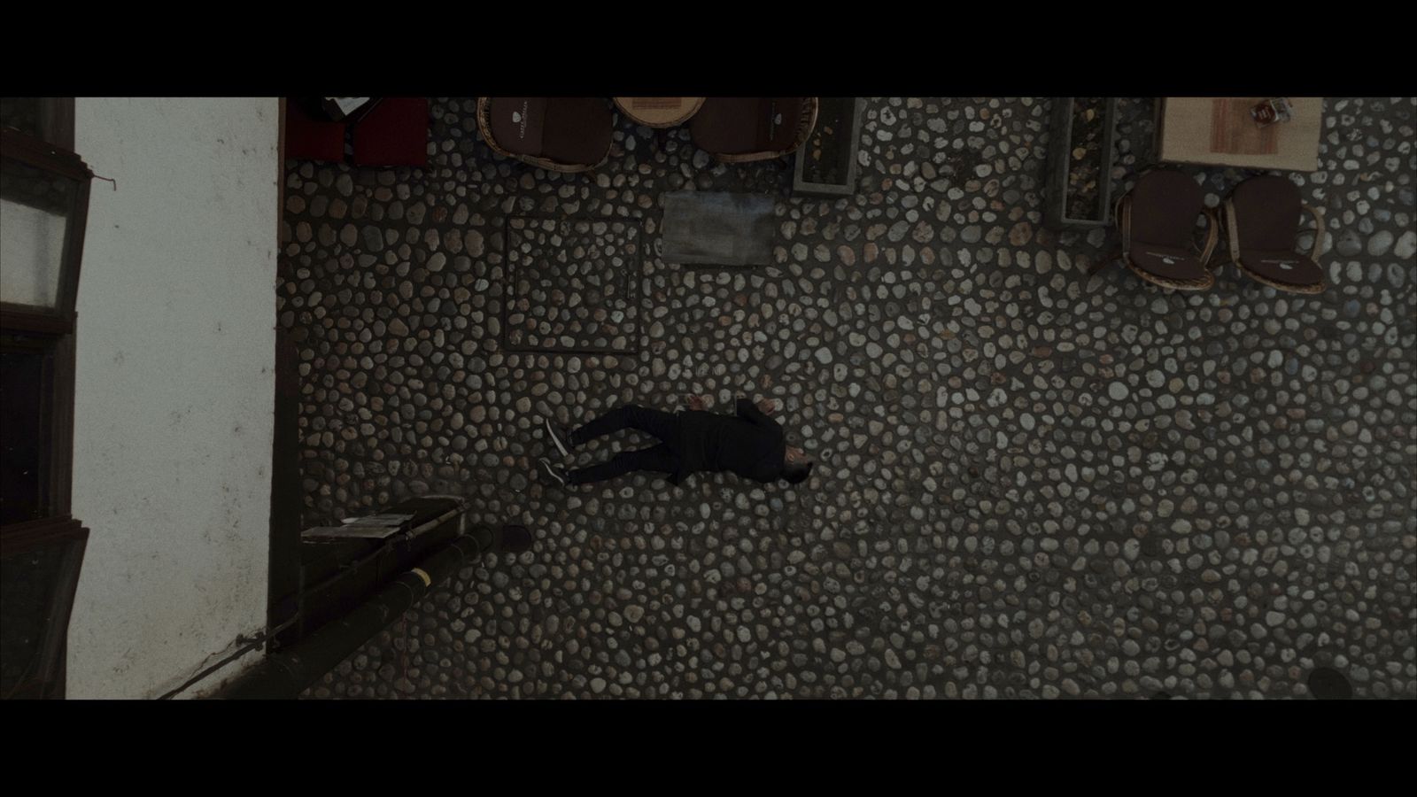 a person laying on the ground next to a wall