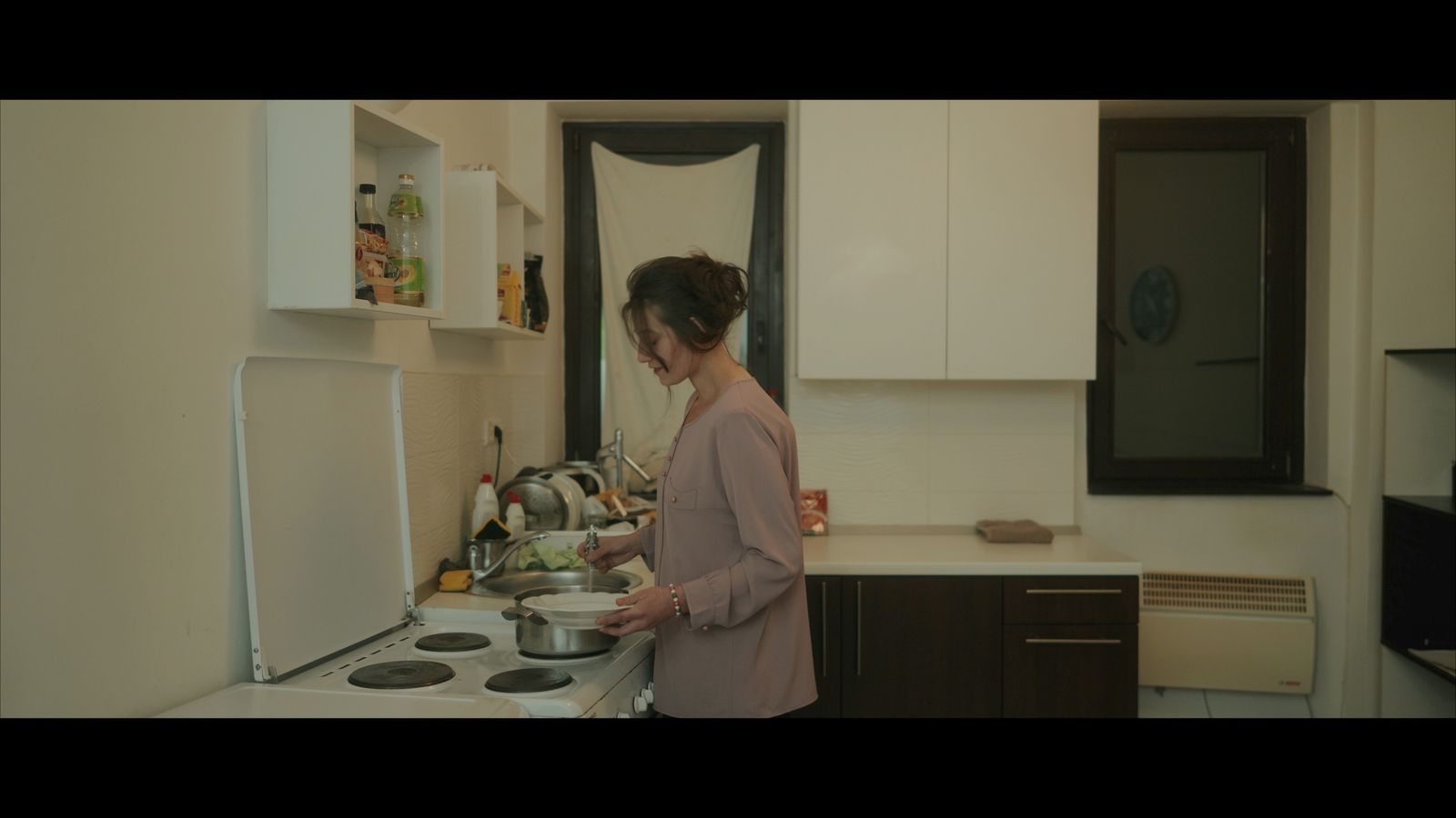 a woman standing in a kitchen preparing food