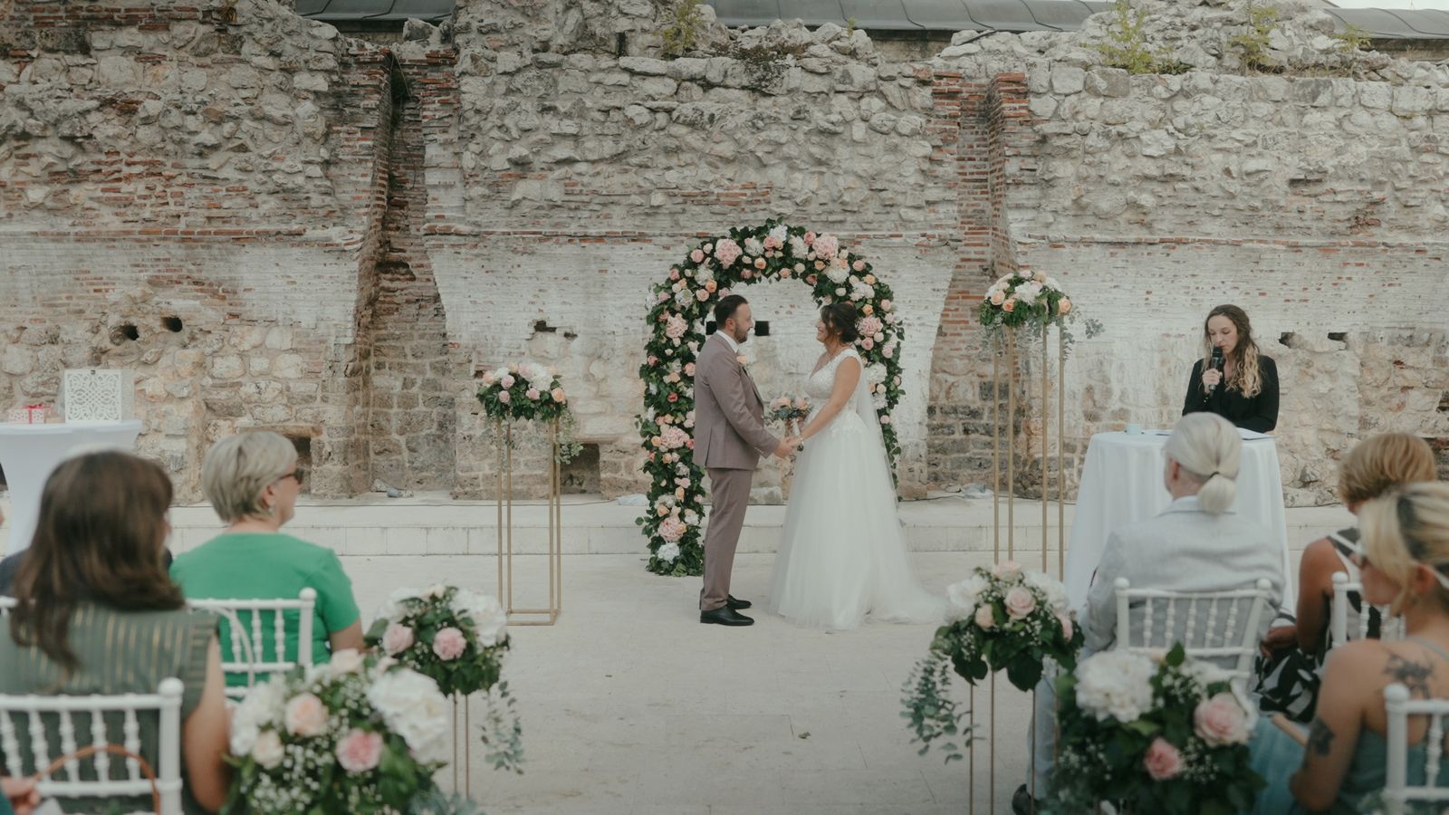 a couple getting married in front of a stone wall