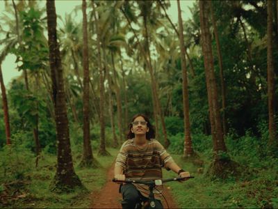 a woman riding a bike down a dirt road