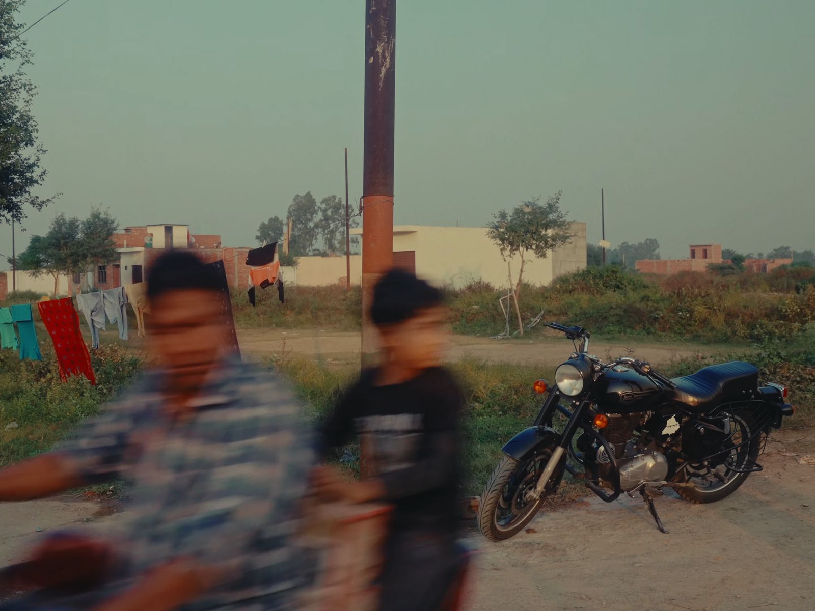 two people standing next to a motorcycle on a road