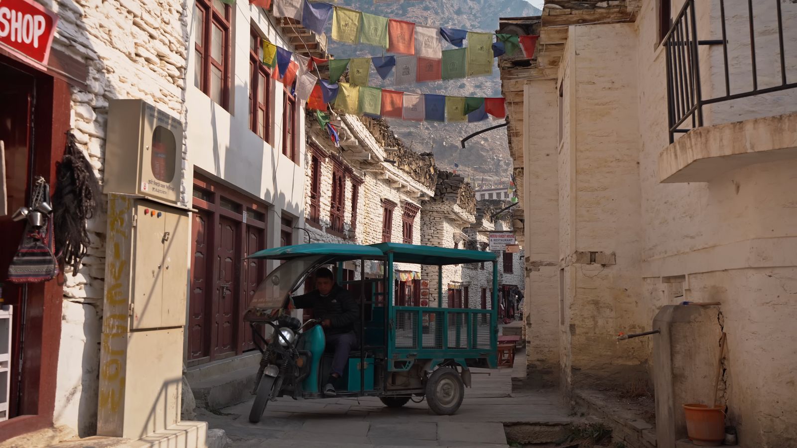 a man driving a cart down a narrow street