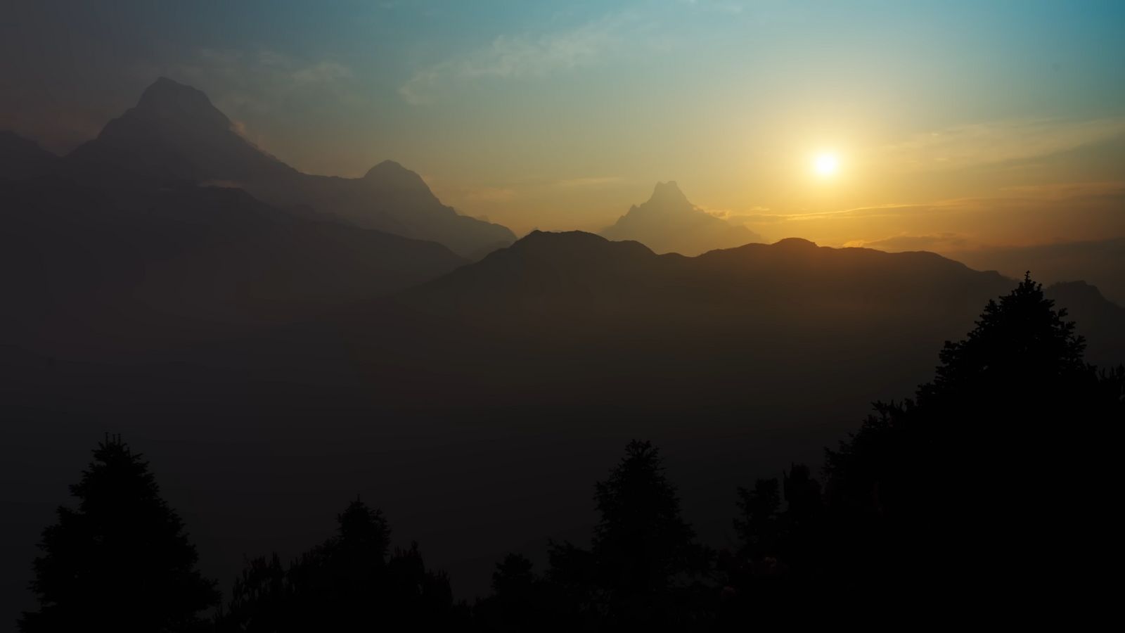 the sun is setting over a mountain range