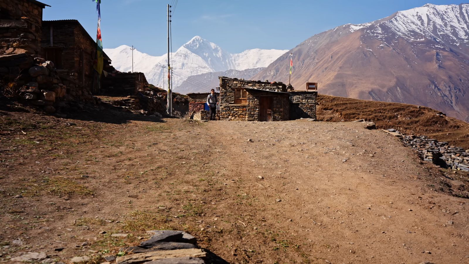 a dirt road leading to a stone building