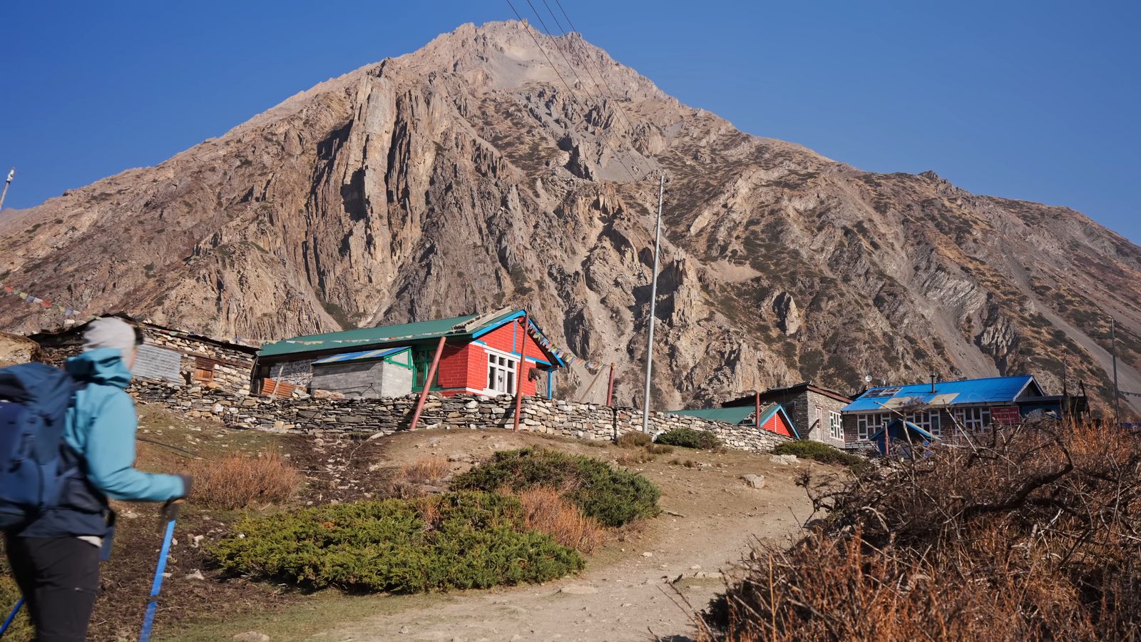 a person with a backpack is standing in front of a mountain