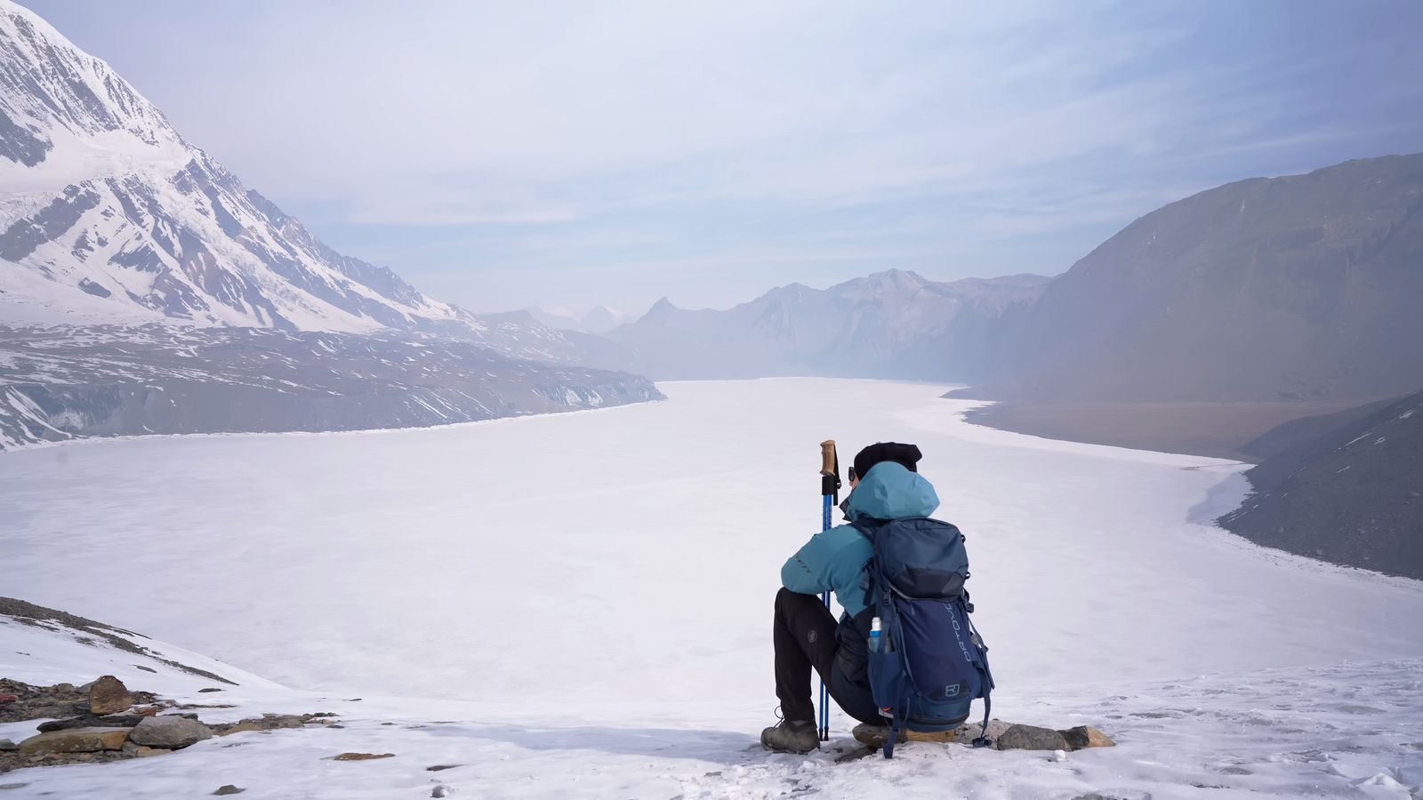 a woman standing on top of a snow covered slope