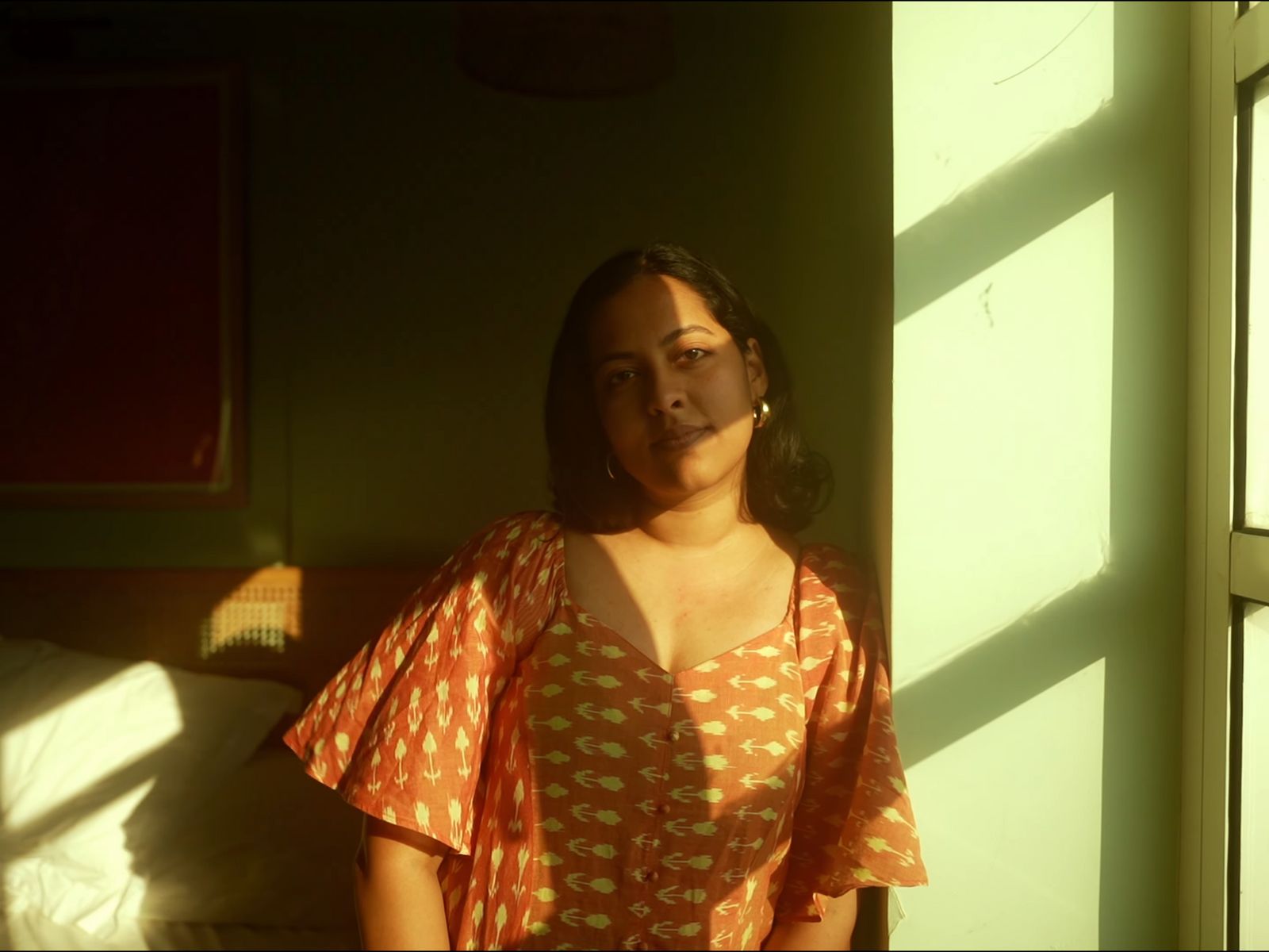 a woman standing next to a window in a room