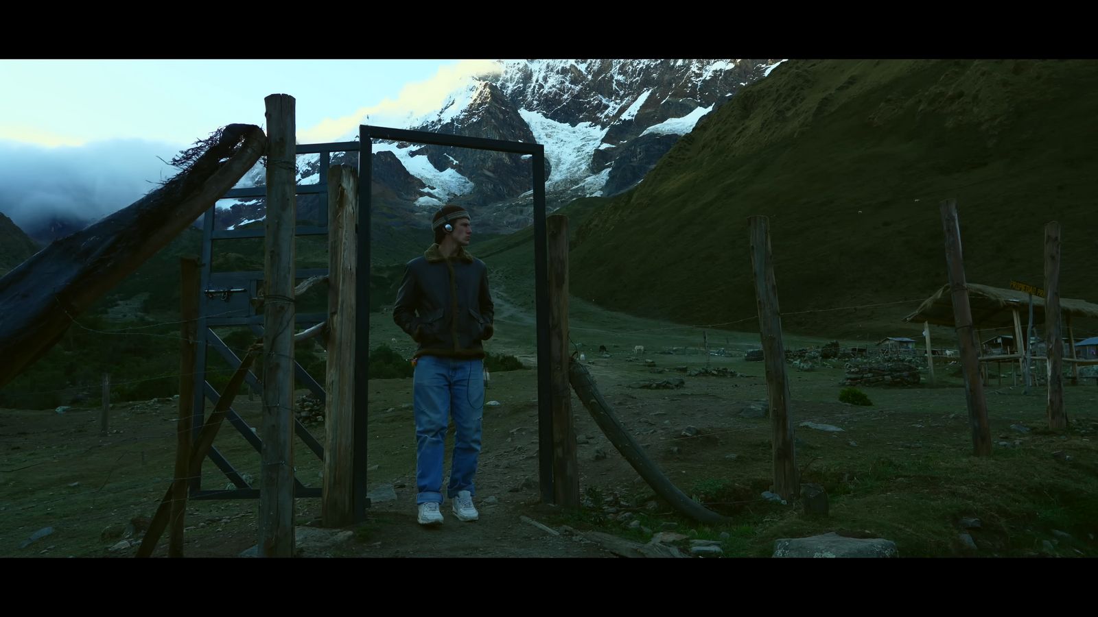 a man standing in front of a wooden structure