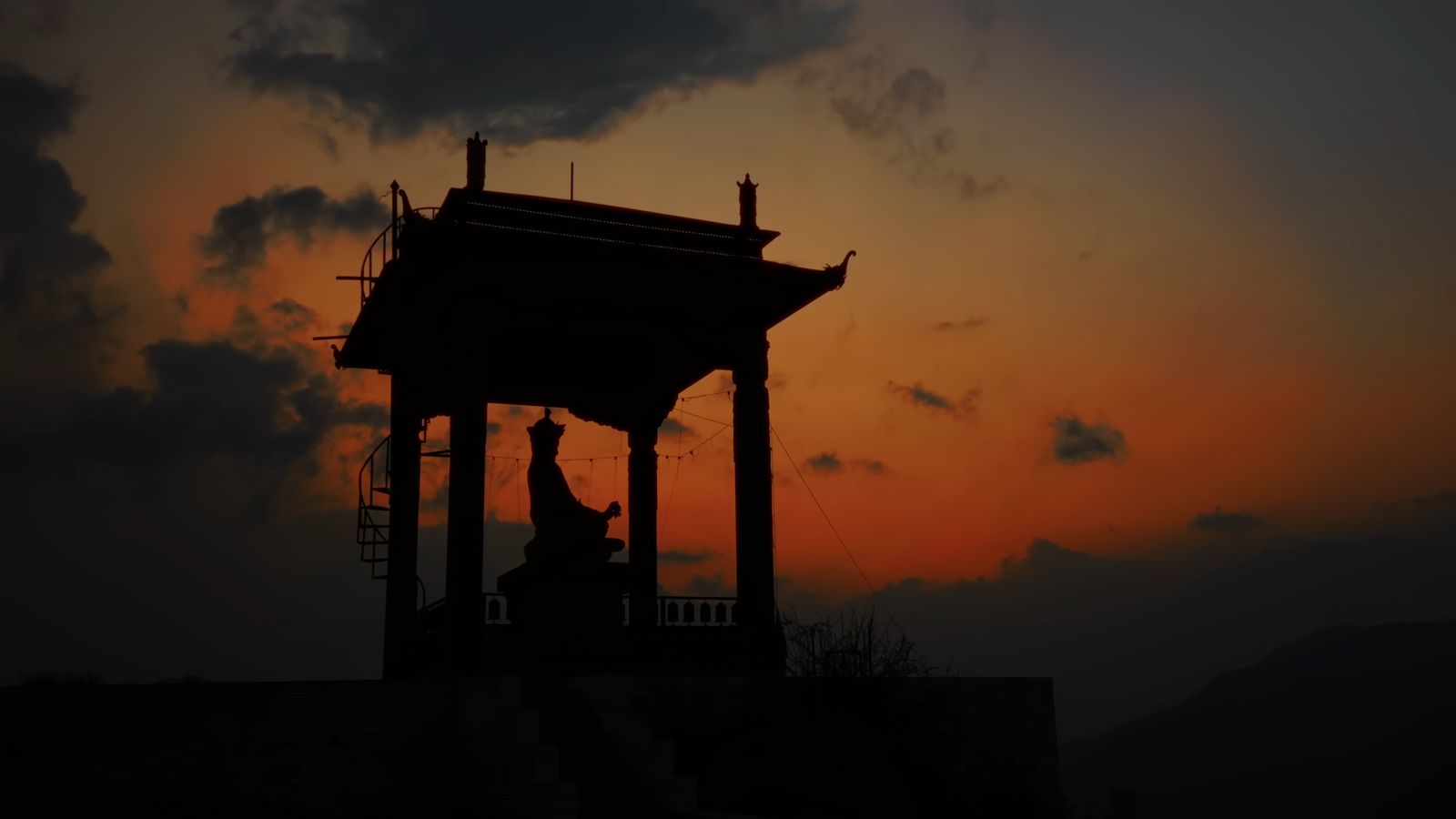 a silhouette of a clock tower against a sunset