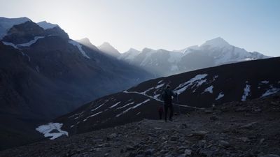 a couple of people walking up a mountain side