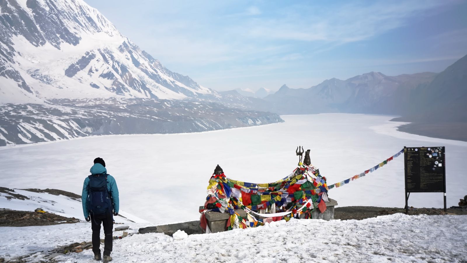 a person standing in the snow with a mountain in the background