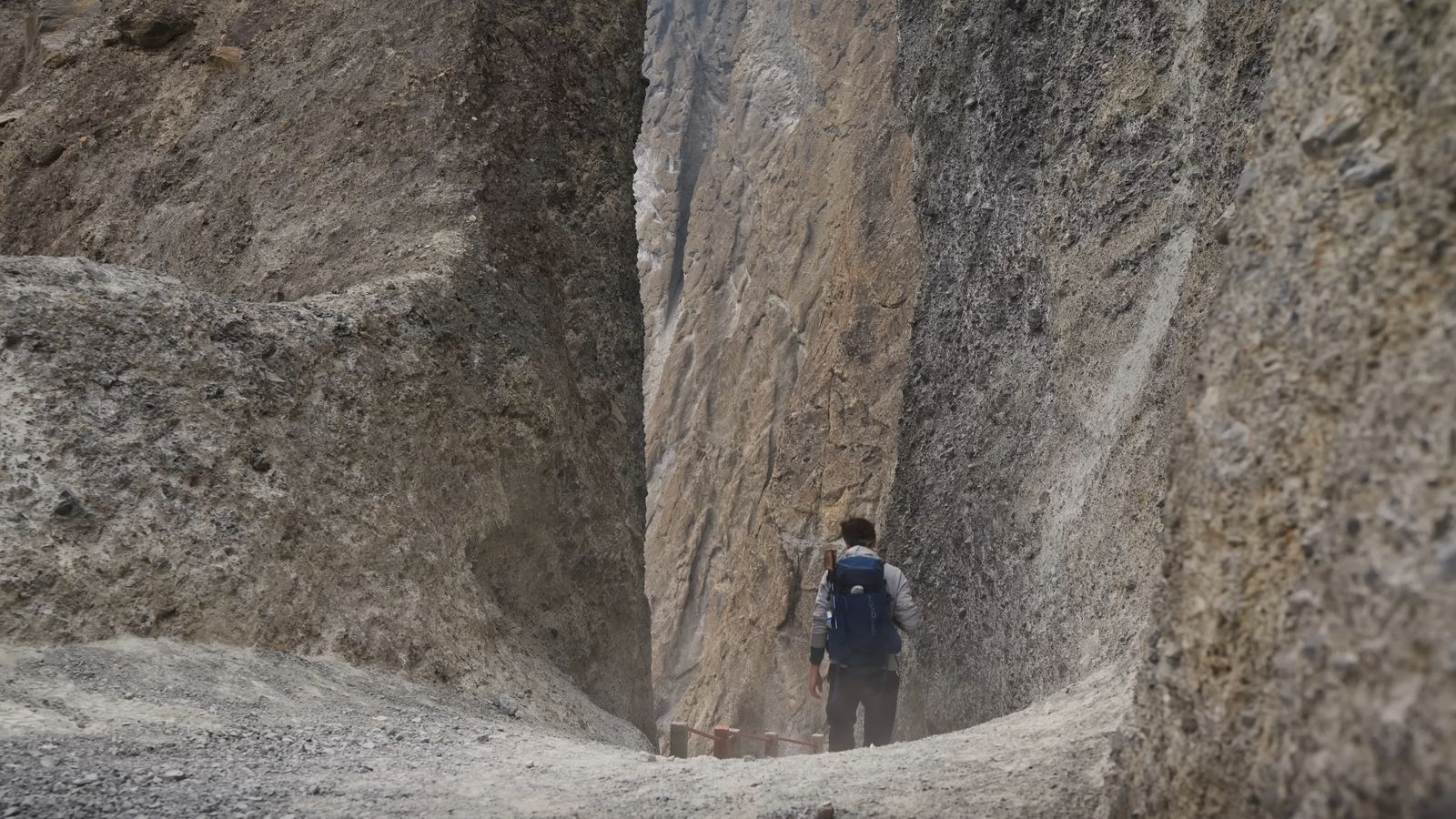 a person standing in between two large rocks