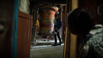 a man standing in a doorway next to a large object