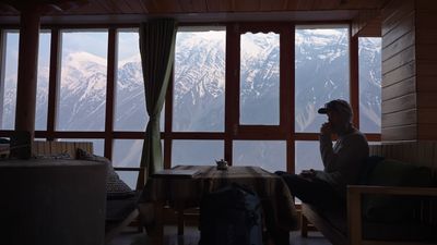 a man sitting on a couch in front of a window