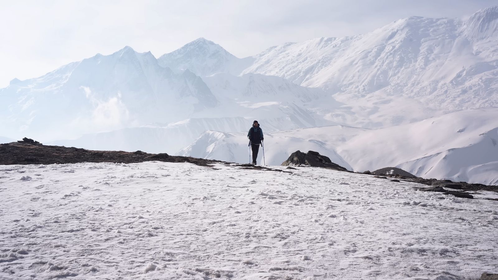 a person standing on top of a snow covered mountain