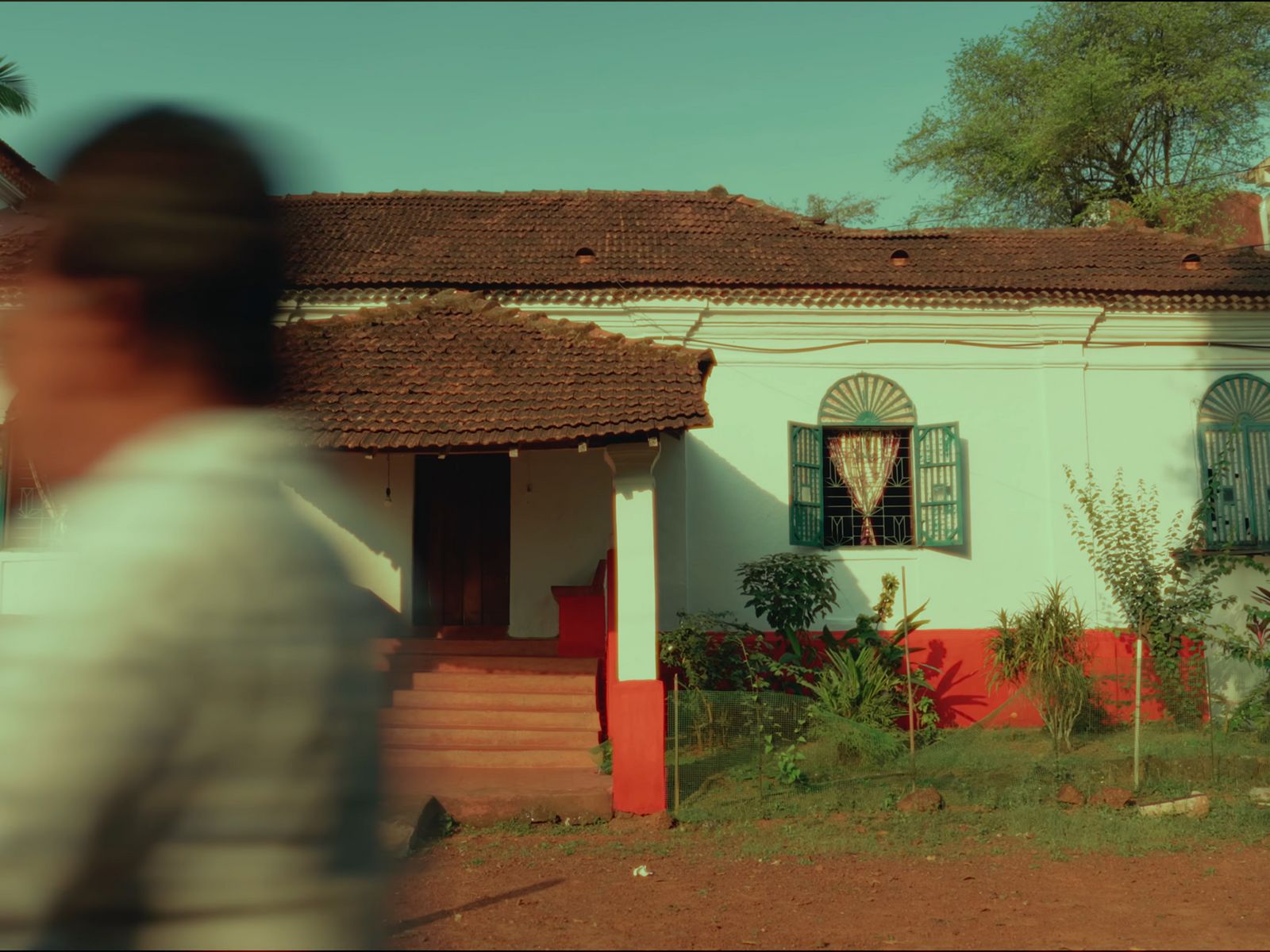 a blurry photo of a man walking in front of a house