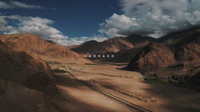 an aerial view of a desert with mountains in the background