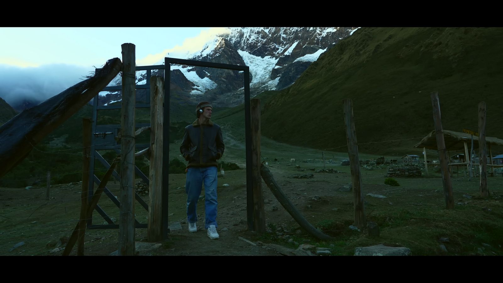 a man standing in front of a wooden structure