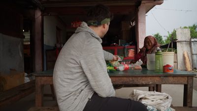 a man sitting at a table with food on it