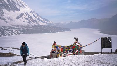 a person standing in the snow with a mountain in the background