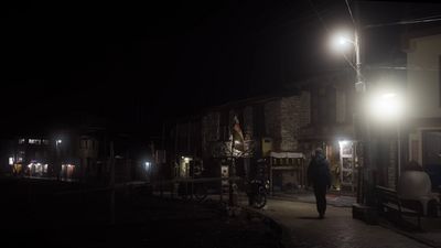 a man walking down a street at night