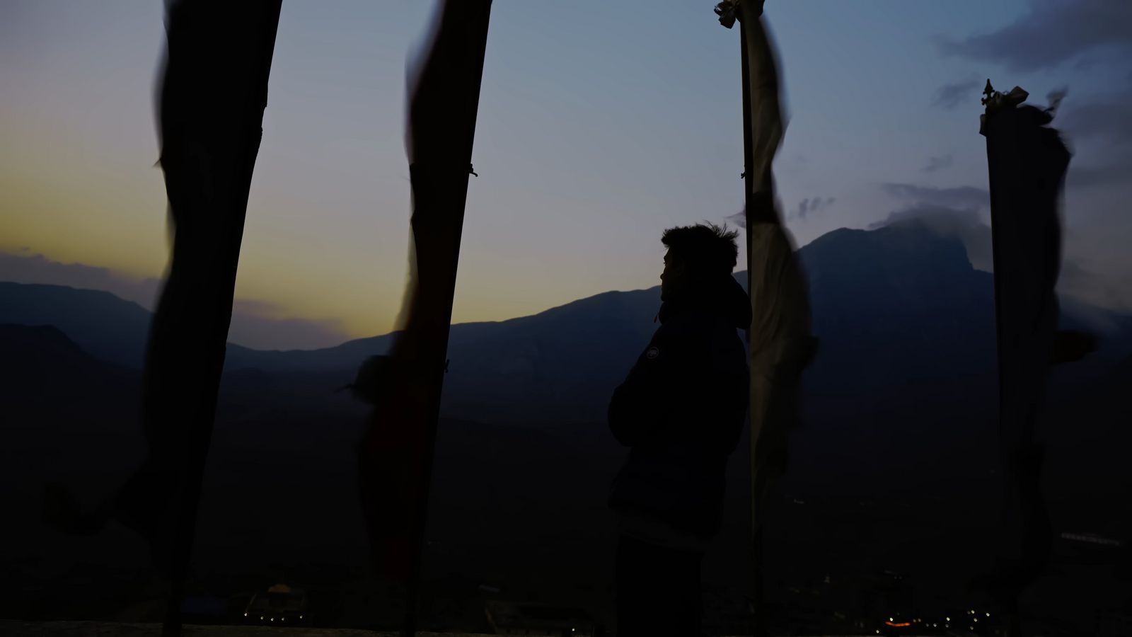 a silhouette of a person holding a flag