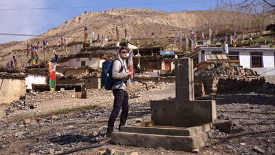 a man with a backpack standing in front of a building