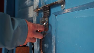 a person opening a blue door with a key