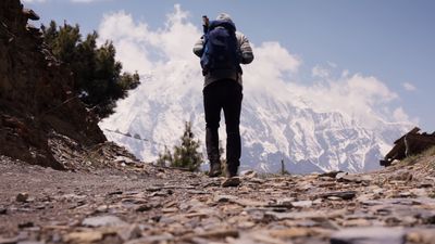 a person with a backpack walking up a mountain