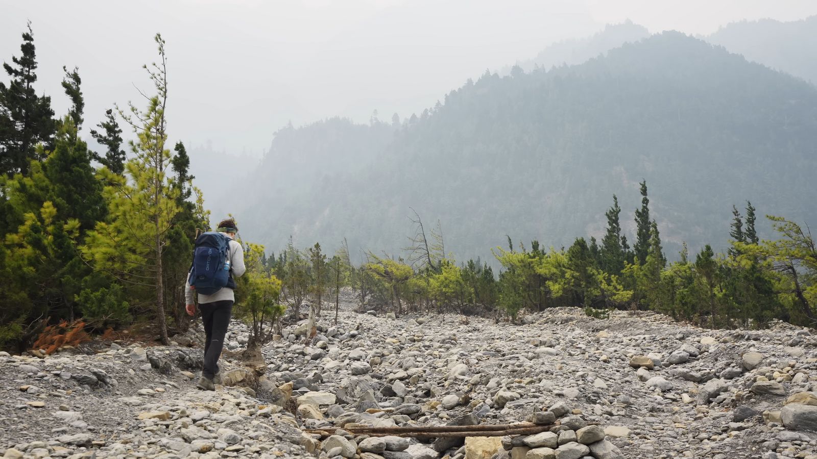 a person hiking up a rocky trail in the mountains