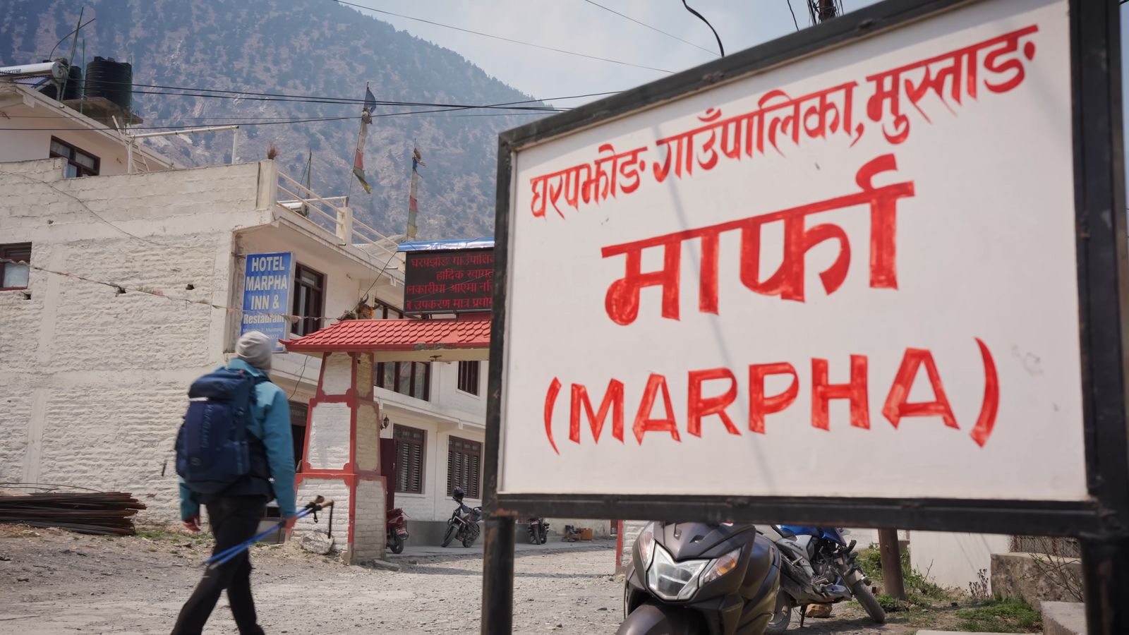 a man walking down a street next to a sign