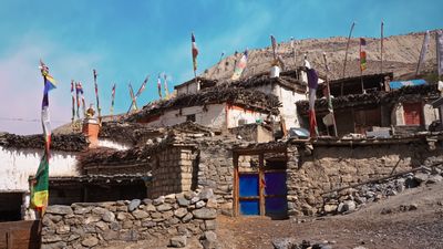 a stone building with flags flying in the wind