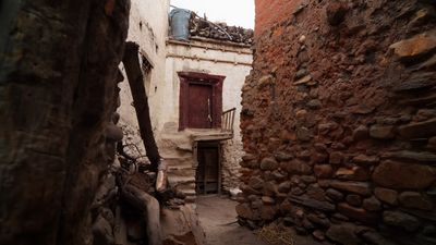 a narrow alley with a door and a window