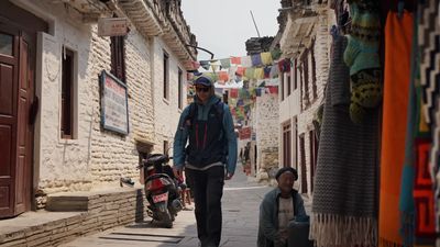 a man walking down a street next to a woman