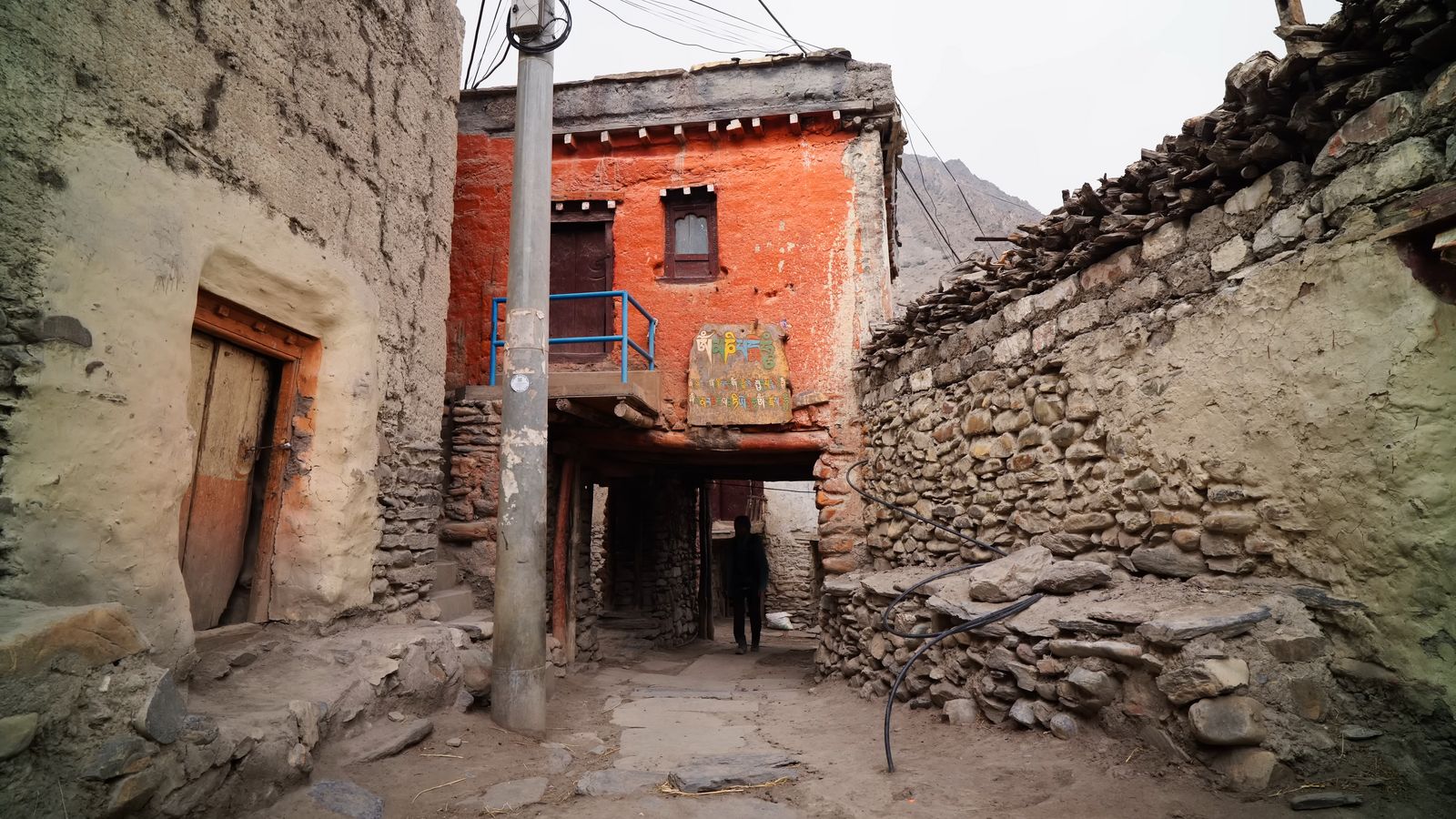 a narrow alley way with a red building