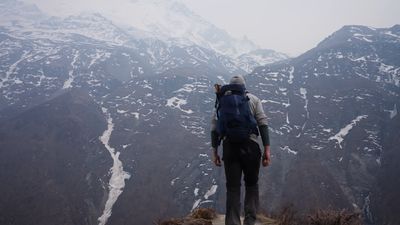 a person with a backpack standing on a mountain