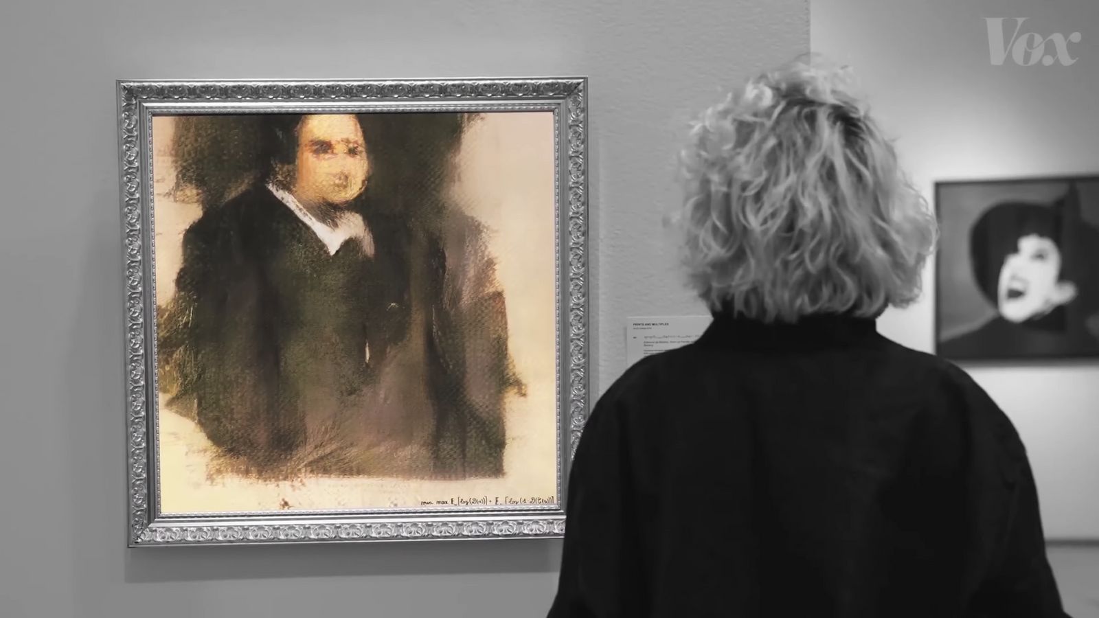 a woman looking at a portrait of a man