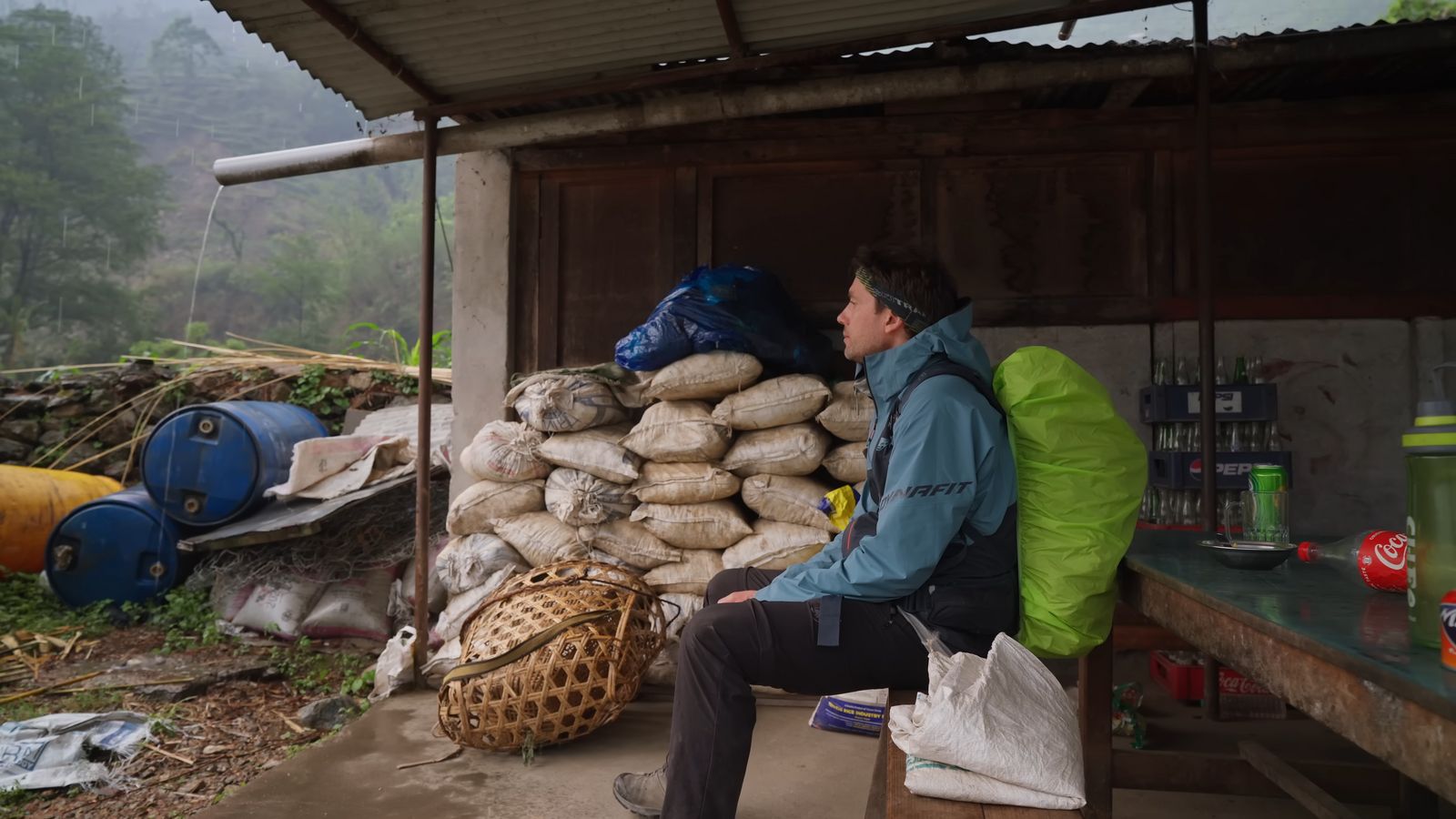 a man sitting on a bench next to a pile of bags