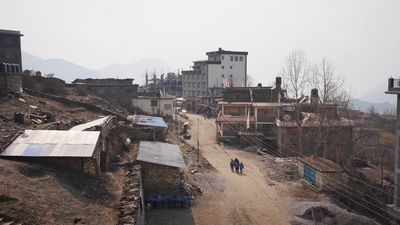 a couple of people walking down a dirt road