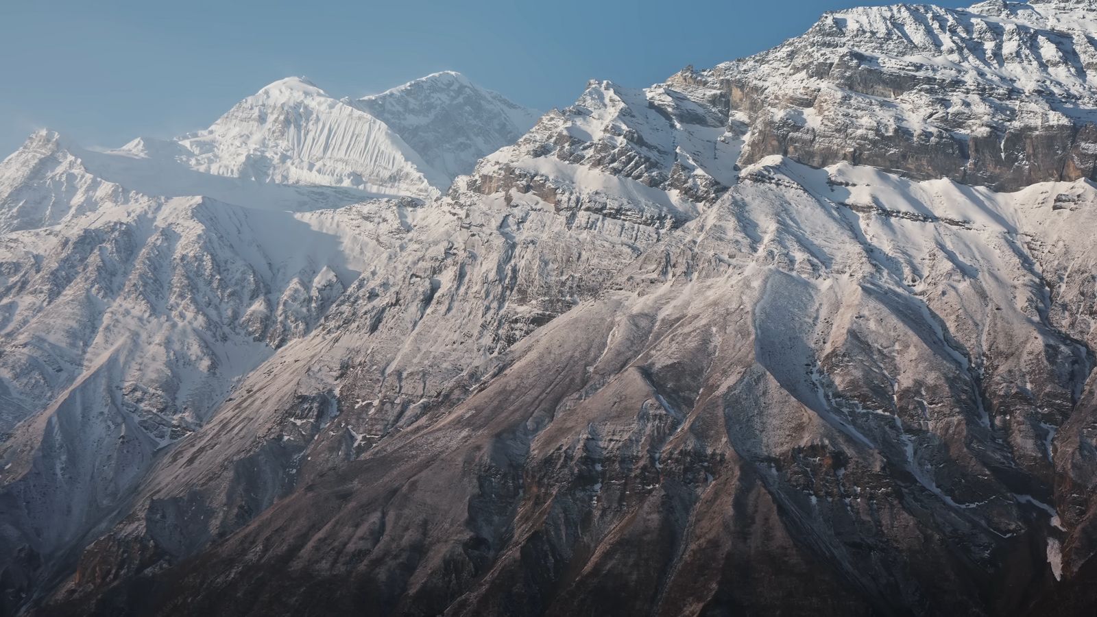 a view of a snowy mountain range from a plane