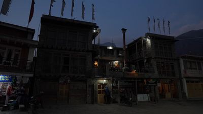 a group of people standing outside of a building at night