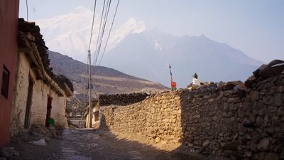 a cobblestone street with mountains in the background