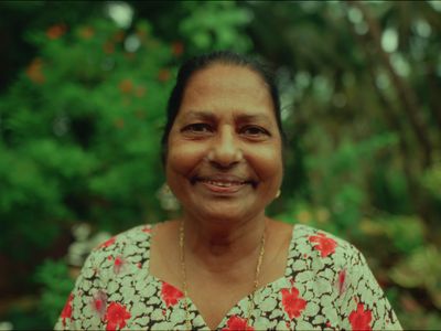 a woman in a floral shirt smiles at the camera