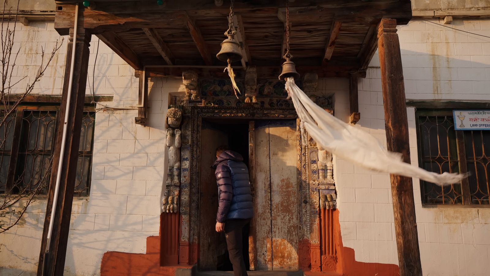 a person standing in front of a doorway with a white cloth hanging from it