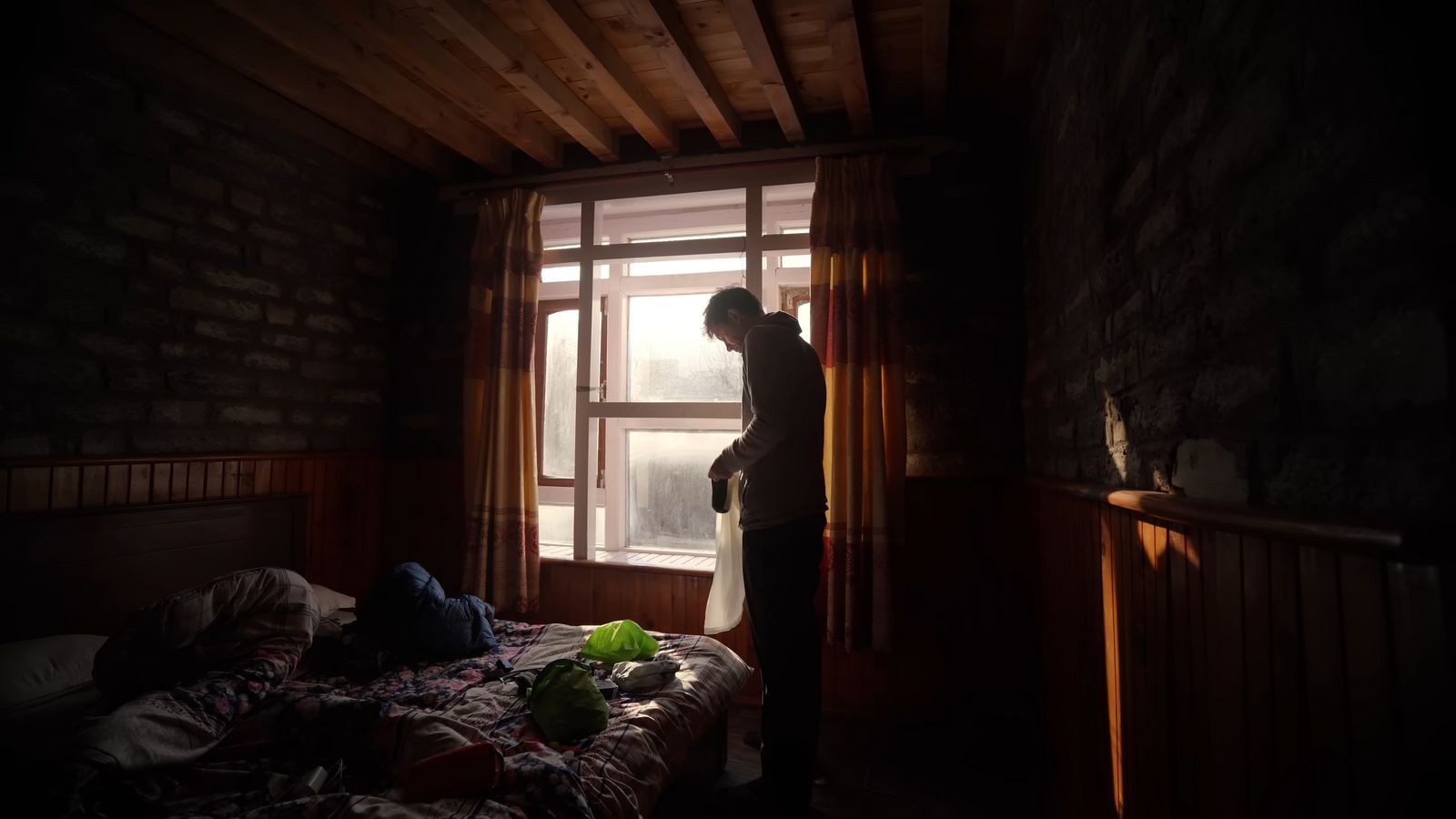 a person standing in front of a window in a dark room