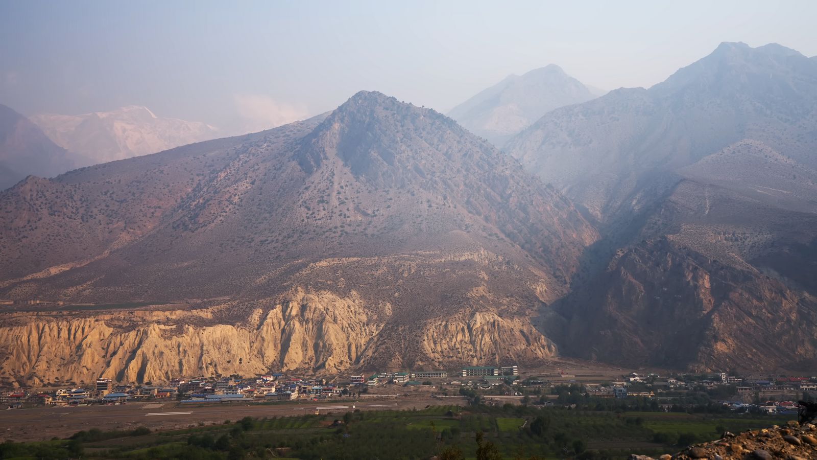 a mountain range with a village in the foreground