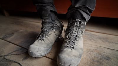 a person standing on a wooden floor wearing gray shoes